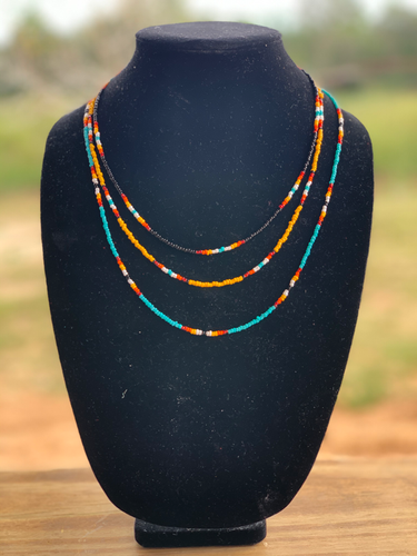 A western style 3 strand necklace. black, yellow, and turquoise serape patterns. 16 inches is the shortest strand, middle strand 18 inches and longest strand is 22 inches. This is cowgirl jewlery